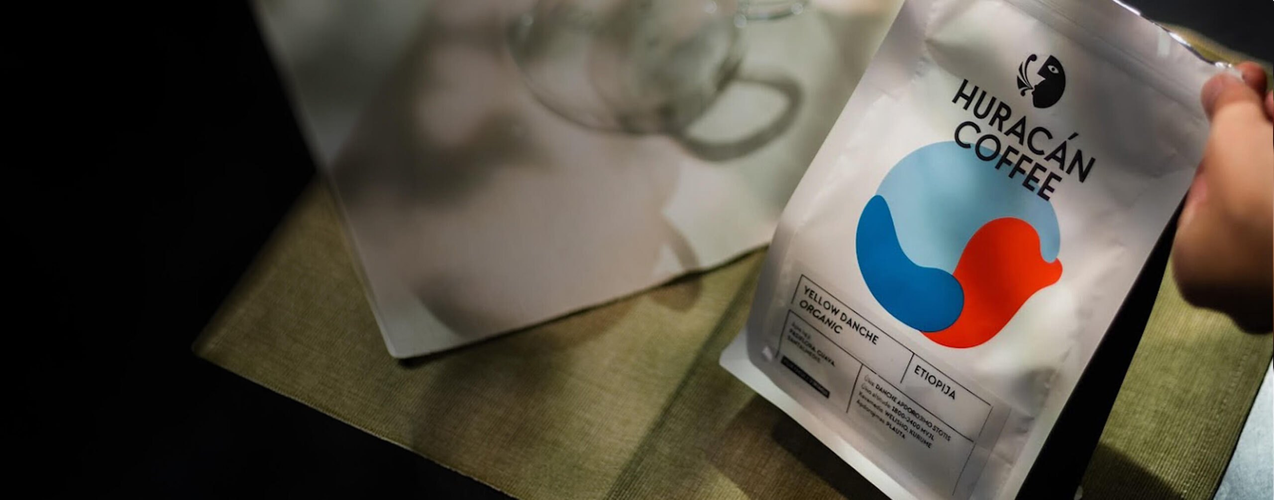 A hand holding a bag of Huracán Coffee